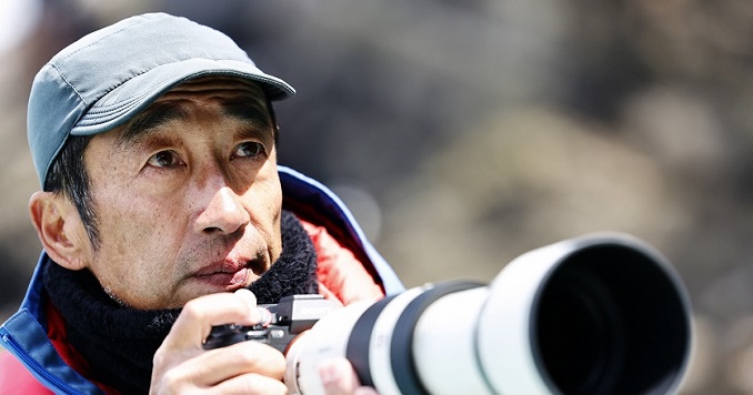 Terasawa sostiene una cámara con un gran objetivo