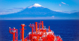 海洋上一艘红色巨舰，以白色盖顶的山峰景致为背景。
