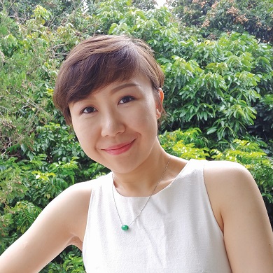 Headshot of woman in front of greenery.