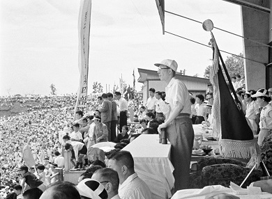 Historical photo taken from a stadium stand showing audience members facing onto the field