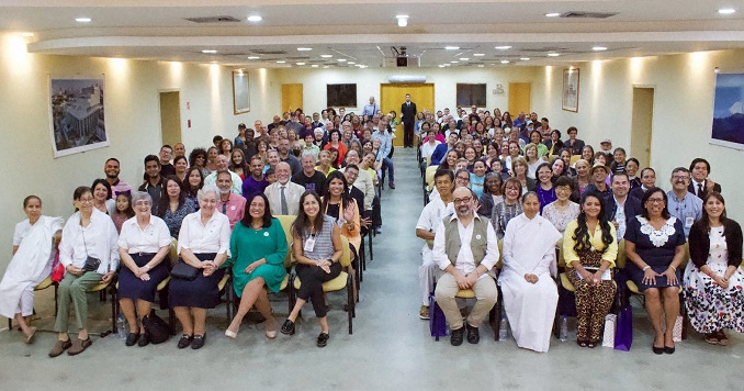 A hall full of diverse people, seated.