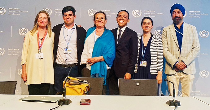 Group photo of six people standing on a stage with UN Climate Change logos on the backdrop.