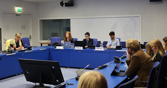 Young people seated around a conference table.