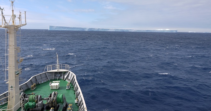The bow of a ship and an iceberg on the horizon.