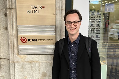 Man standing in front of a sign on the outside of a building.