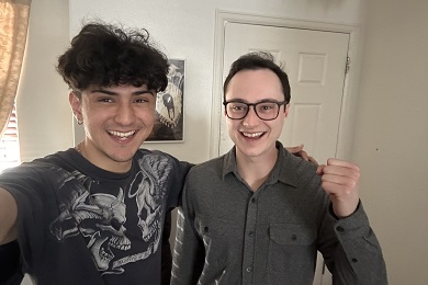 Two men smiling and posing for a selfie.