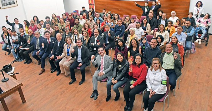 Un grupo de personas sentadas en una sala posan para una foto.