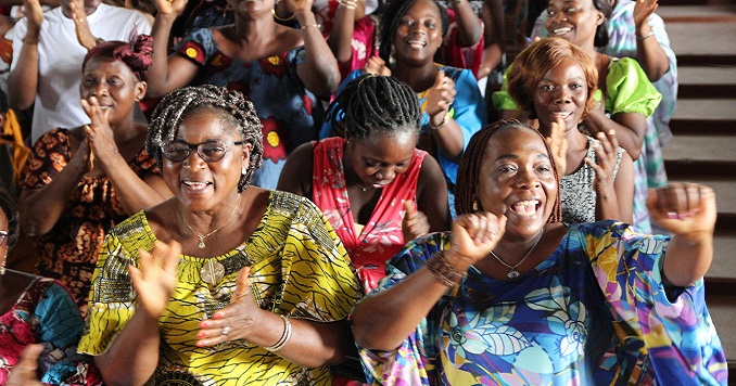 People cheering and smiling at a conference.