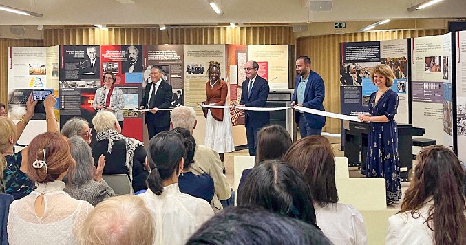 People dressed formally at a ribbon-cutting ceremony for a new exhibition.