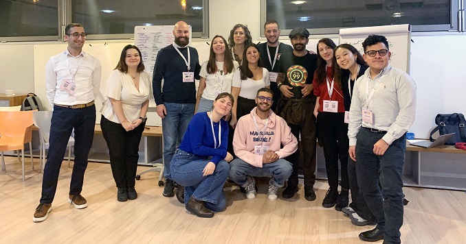 Young people in a small hall room gather for a group photo.