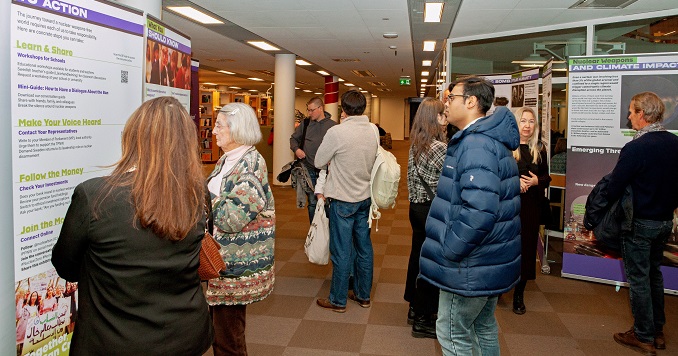 People looking at exhibition panels in a large room.