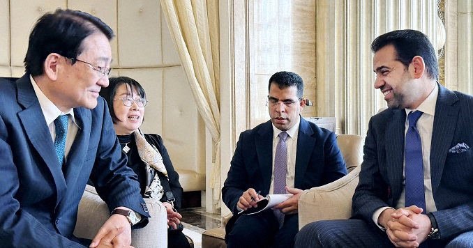 Four seated people dressed formally engaging a lively discussion.