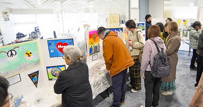 People viewing children’s artwork at an exhibition.