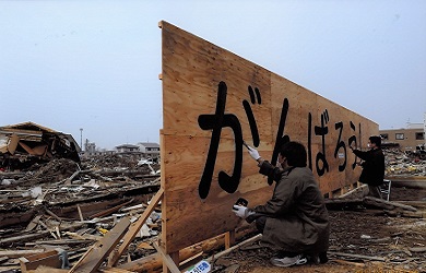 Dos hombres pintan letras sobre un gran cartel de madera